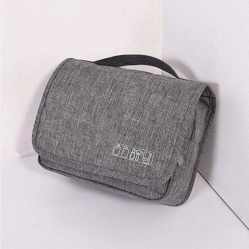 Beauty case grigio chiuso con maniglia e un simbolo bianco di flaconi e pennello