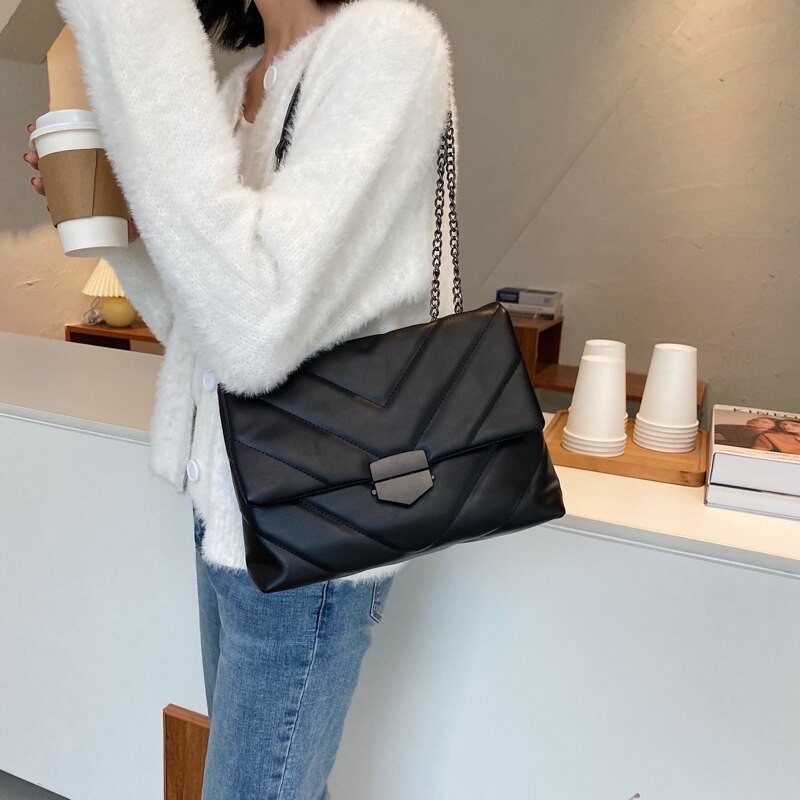 Borsa trapuntata nera su una spalla con tracolla a catena sottile e chiusura nera