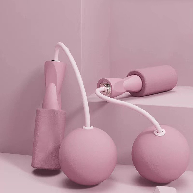 Maniglie rosa con cavi corti e palline rosa su sfondo rosa