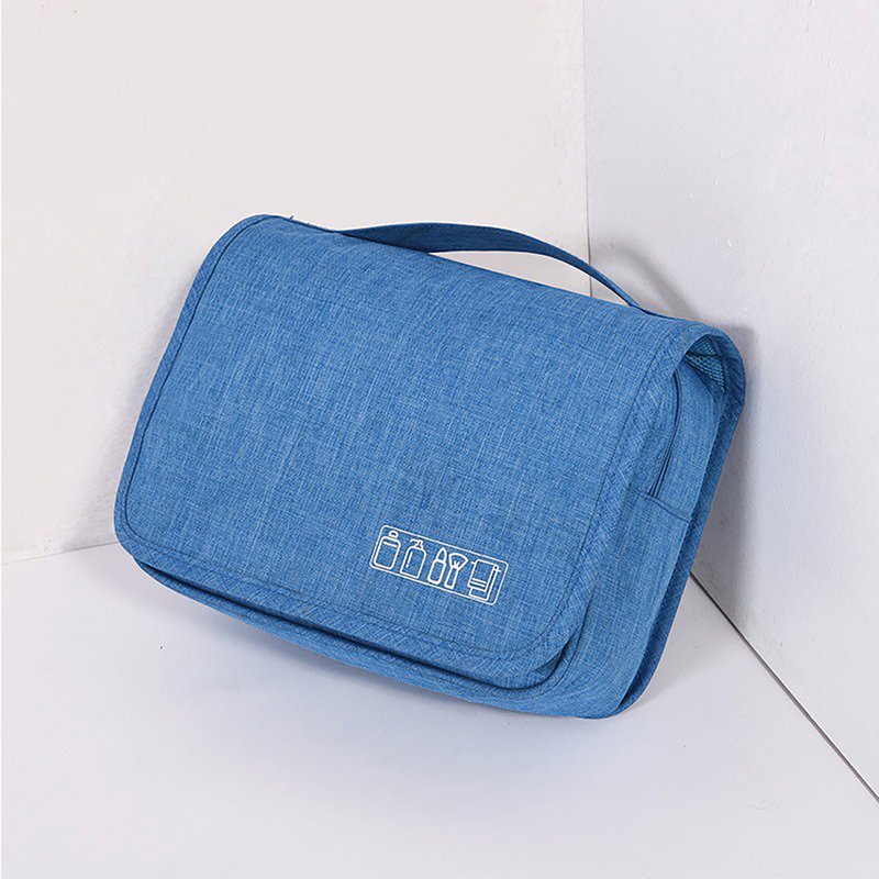 Beauty case blu chiuso, appoggiato a un angolo, con maniglia