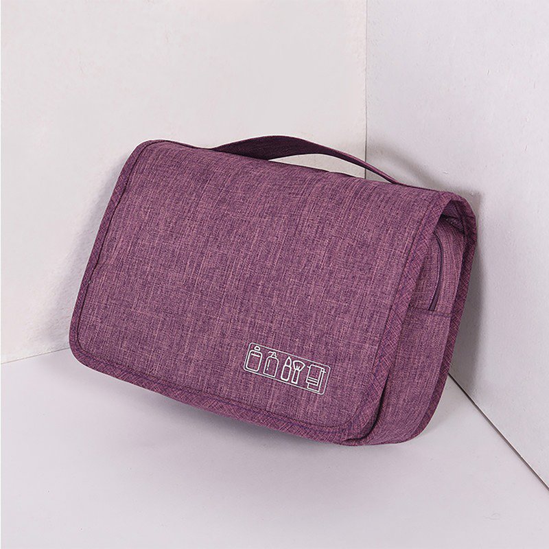 Beauty case viola chiuso, appoggiato a un angolo, con maniglia