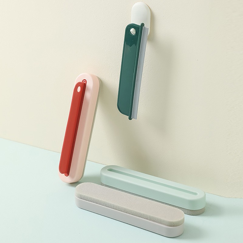 Lama verde appesa per il foro a un gancio bianco, con un tergivetro rosso e due supporti appoggiati