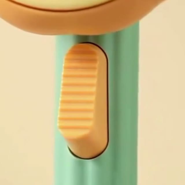 Primo piano del pulsante arancione a scorrimento sul manico verde